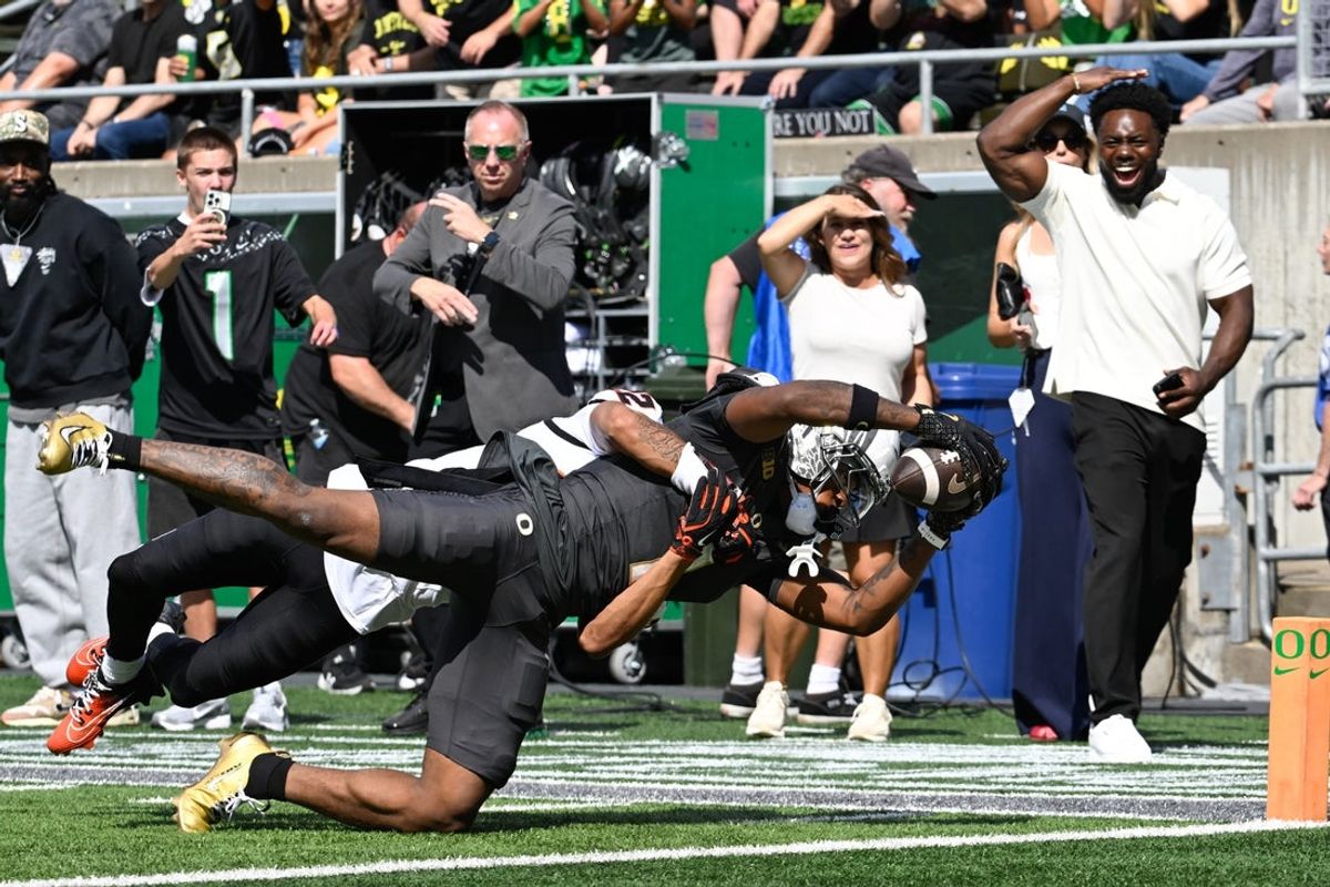 Sep 20, 2025; Eugene, Oregon, USA; Oregon Ducks wide receiver Dakorien Moore (1) dives to score a touchdown defended by Oregon State Beavers defensive back Jalil Tucker (22) during the first quarter of the game at Autzen Stadium. Mandatory Credit: Troy Wayrynen-Imagn Images