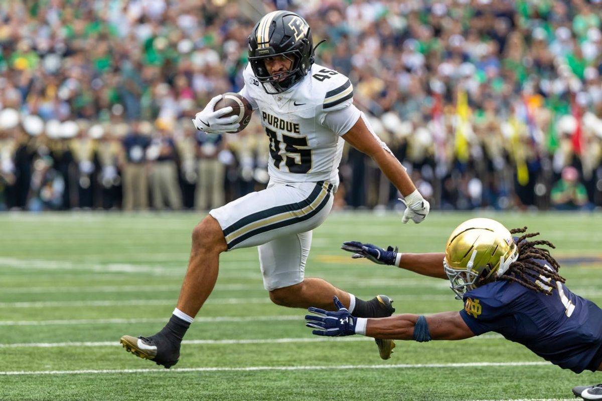 Sep 20, 2025; South Bend, Indiana, USA; Purdue Boilermakers running back Devin Mockobee (45) jumps to avoid a tackle attempt by Notre Dame Fighting Irish safety Jalen Stroman (7) during the first half at Notre Dame Stadium. Mandatory Credit: Michael Caterina-Imagn Images