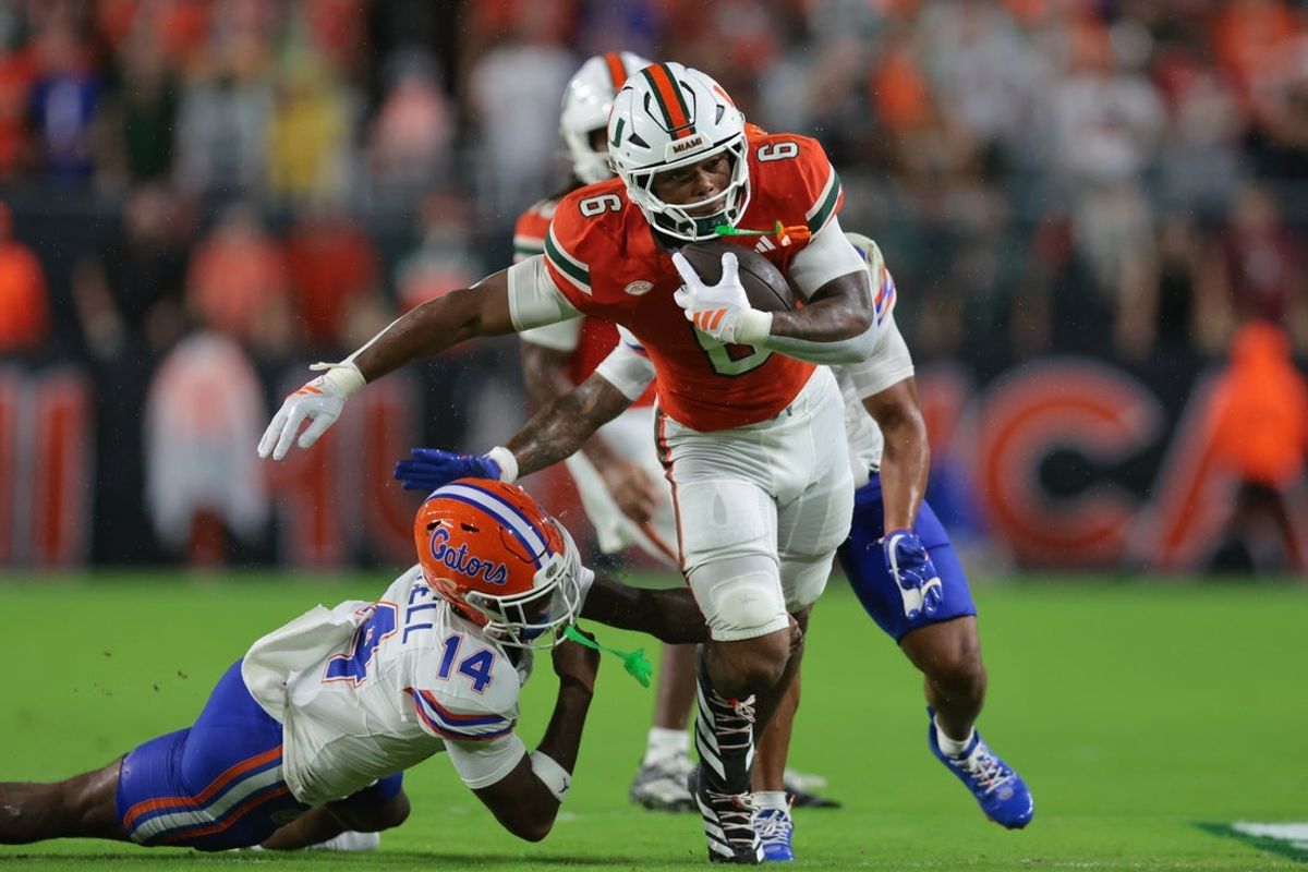 Sep 20, 2025; Miami Gardens, Florida, USA; Miami Hurricanes running back CharMar Brown (6) carries the football against Florida Gators defensive back Jordan Castell (14) during the first quarter at Hard Rock Stadium. Mandatory Credit: Sam Navarro-Imagn Images