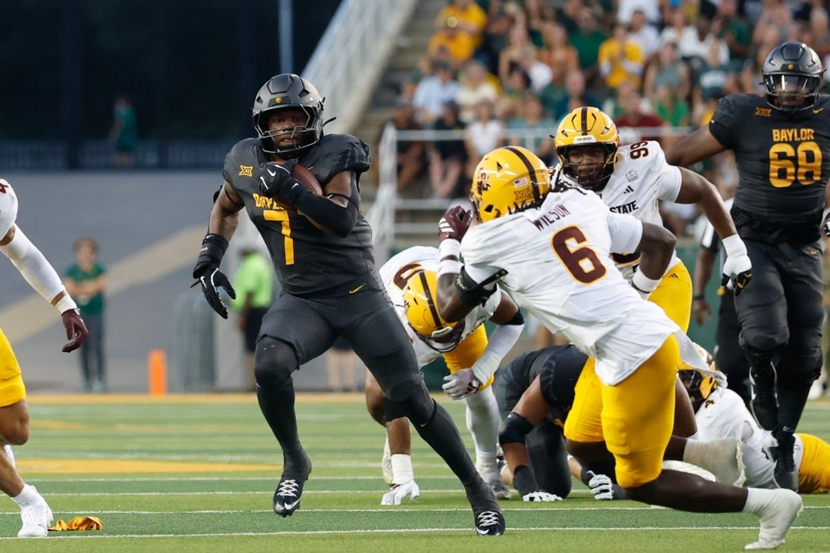 Sep 20, 2025; Waco, Texas, USA; Baylor Bears running back Bryson Washington (7) carries the ball as Arizona State Sun Devils safety Adrian Wilson (6) defends during the first half at McLane Stadium. Mandatory Credit: Chris Jones-Imagn Images