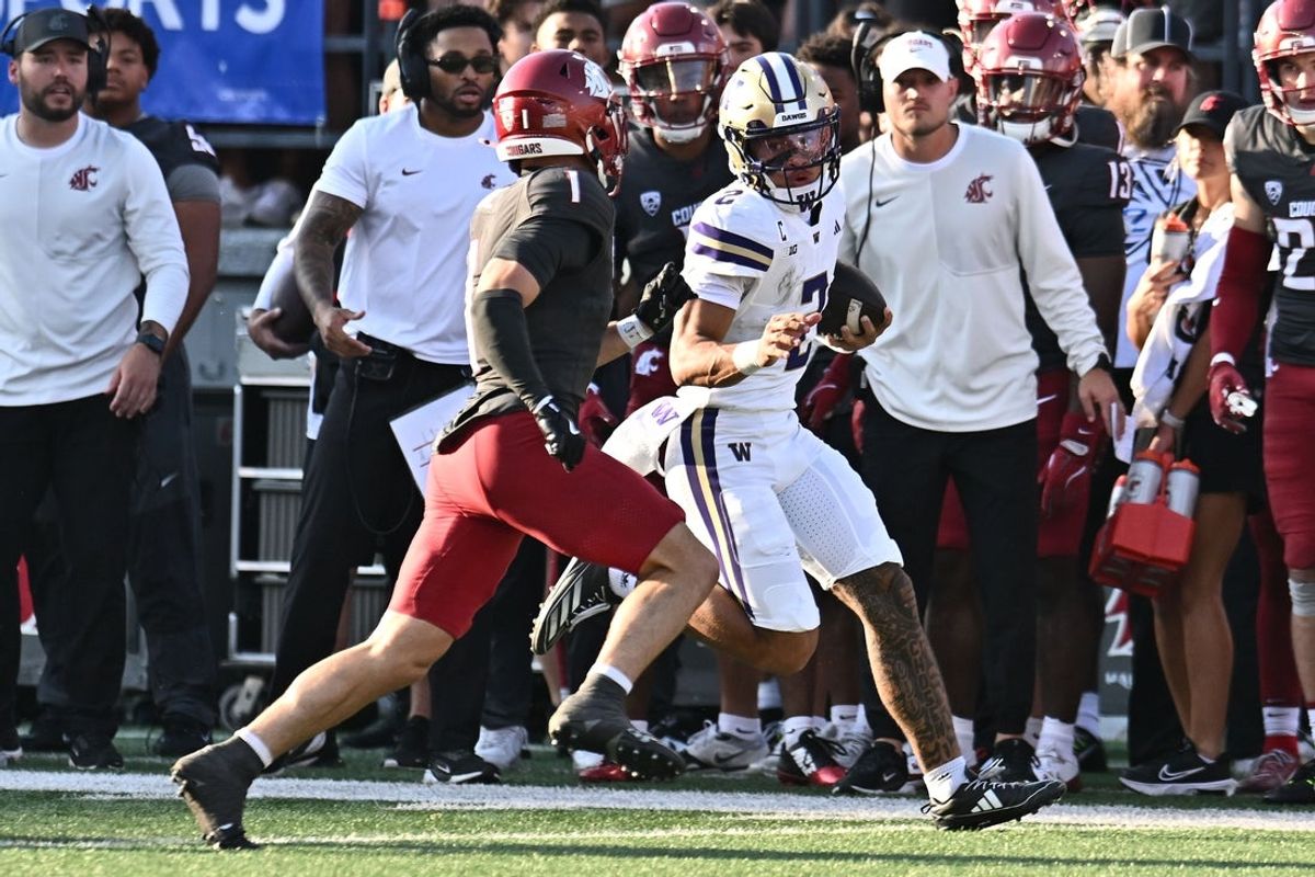 Sep 20, 2025; Pullman, Washington, USA; Washington Huskies quarterback Demond Williams Jr. (2) carries the ball against Washington State Cougars safety Tucker Large (1) in the first half of Apple Cup at Gesa Field at Martin Stadium. Mandatory Credit: James Snook-Imagn Images
