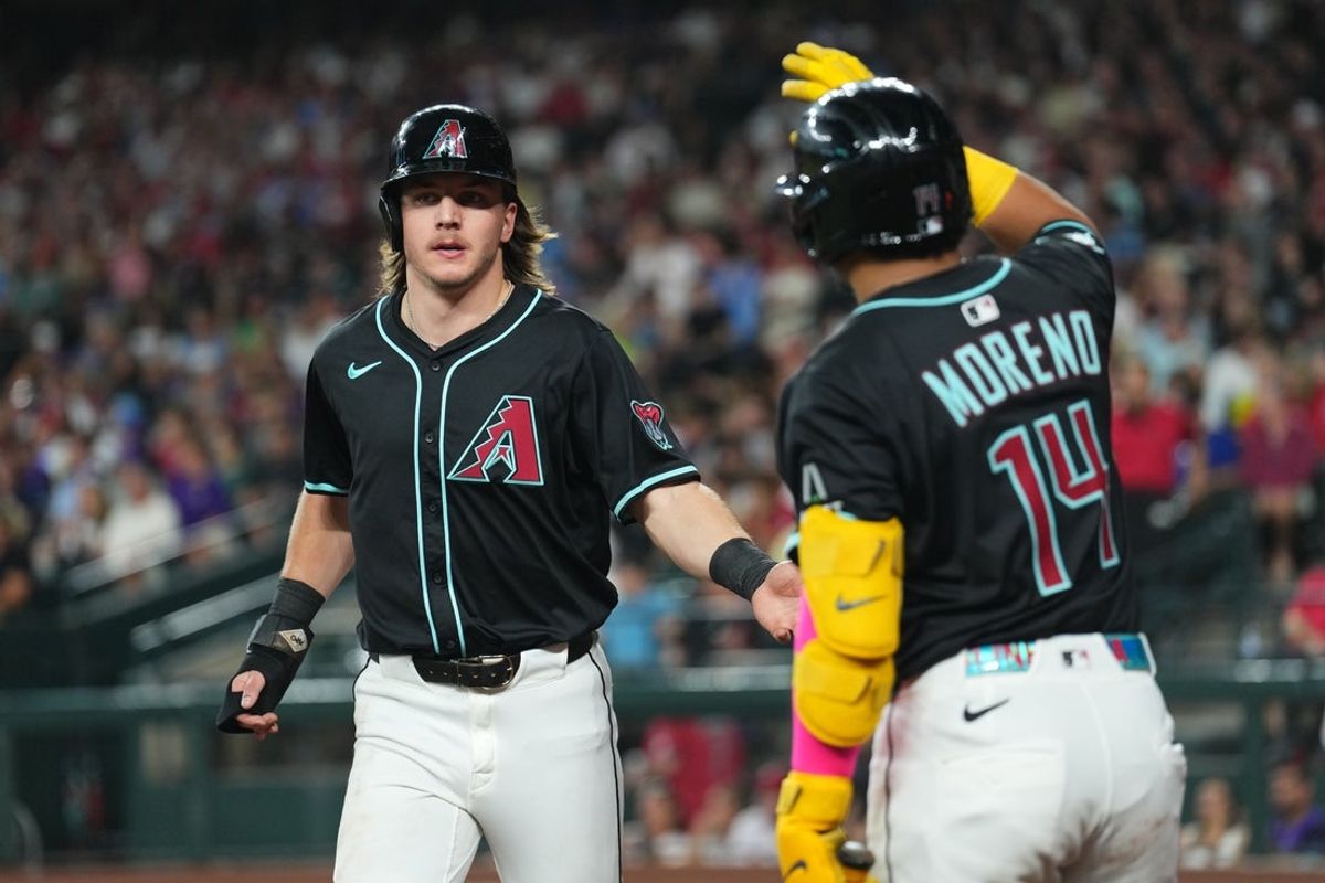 Sep 20, 2025; Phoenix, Arizona, USA; Arizona Diamondbacks outfielder Jake McCarthy (31) slaps hands with Arizona Diamondbacks catcher Gabriel Moreno (14) after scoring a run against the Philadelphia Phillies during the third inning at Chase Field. Mandatory Credit: Joe Camporeale-Imagn Images