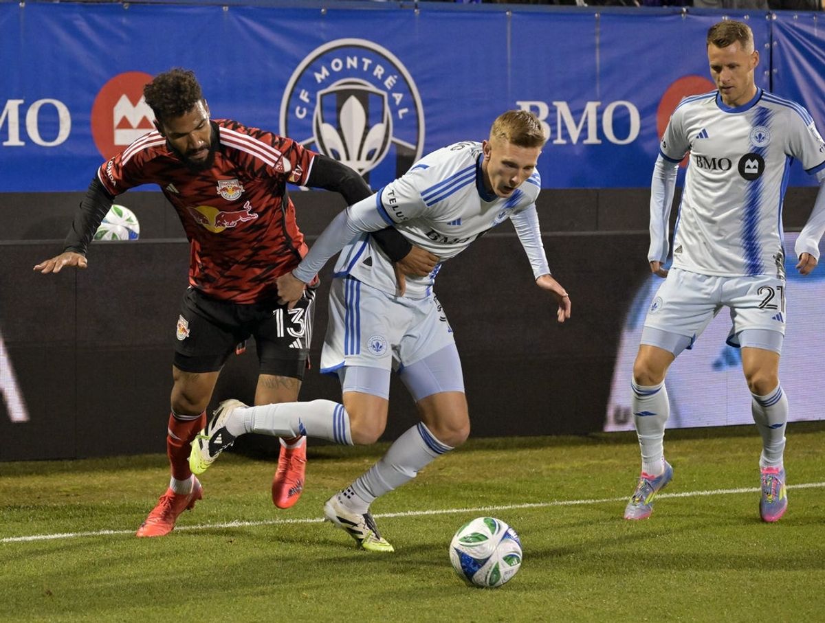 Sep 20, 2025; Montreal, Province of Quebec, CAN; New York Red Bulls forward Eric Maxim Choupo-Moting (13) plays the ball and CF Montreal defender Brandon Craig (5) defends with teammate midfielder Fabian Herbers (21) during the second half at Saputo Stadium. Mandatory Credit: Eric Bolte-Imagn Images