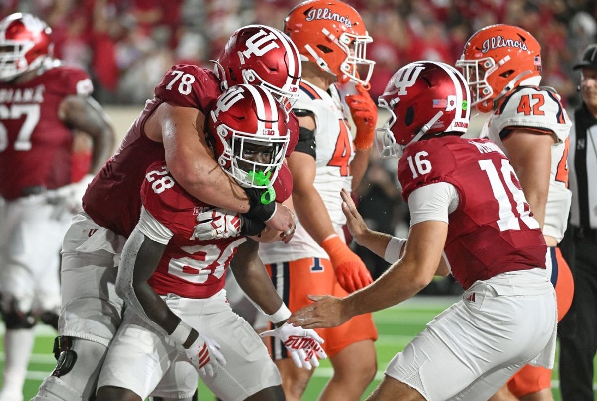 Sep 20, 2025; Bloomington, Indiana, USA; Indiana Hoosiers offensive lineman Pat Coogan (78) and Indiana Hoosiers quarterback Fernando Mendoza (15) celebrate with Indiana Hoosiers running back Khobie Martin (28) after a touchdown during the second half against the Illinois Fighting Illini at Memorial Stadium. Mandatory Credit: Robert Goddin-Imagn Images