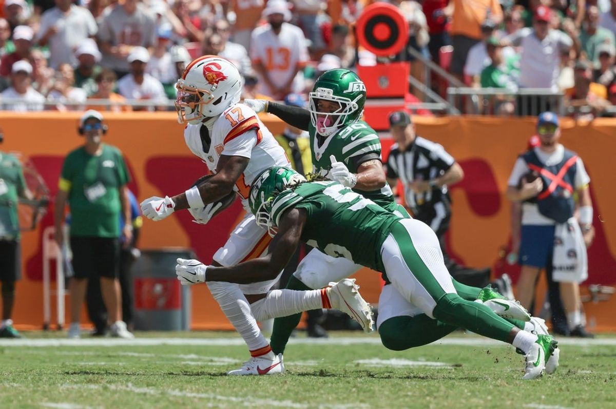 Sep 21, 2025; Tampa, Florida, USA;Tampa Bay Buccaneers wide receiver Sterling Shepard (17) runs with the ball as New York Jets cornerback Michael Carter II (30) and linebacker Quincy Williams (56) defends  during the first quarter at Raymond James Stadium. Mandatory Credit: Kim Klement Neitzel-Imagn Images