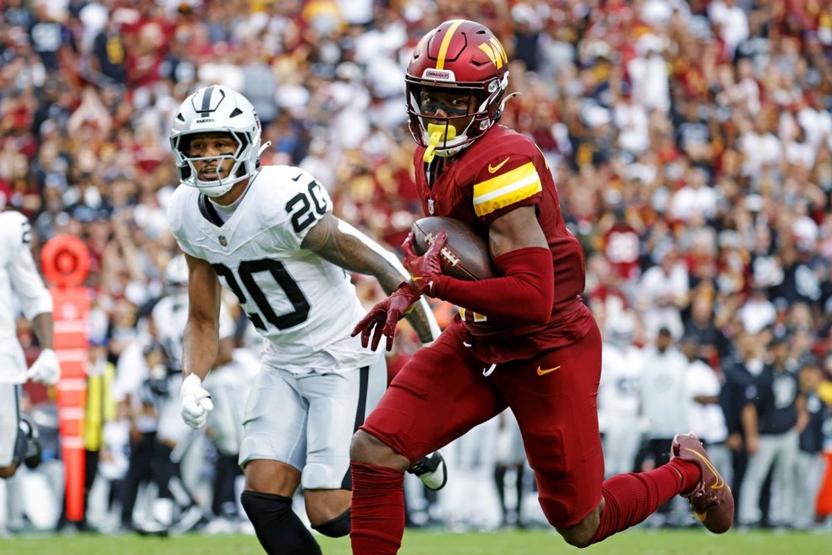 Sep 21, 2025; Landover, Maryland, USA; Washington Commanders wide receiver Terry McLaurin (17) runs the ball during the second half as Las Vegas Raiders safety Isaiah Pola-Mao (20) defends at Northwest Stadium. Mandatory Credit: Amber Searls-Imagn Images