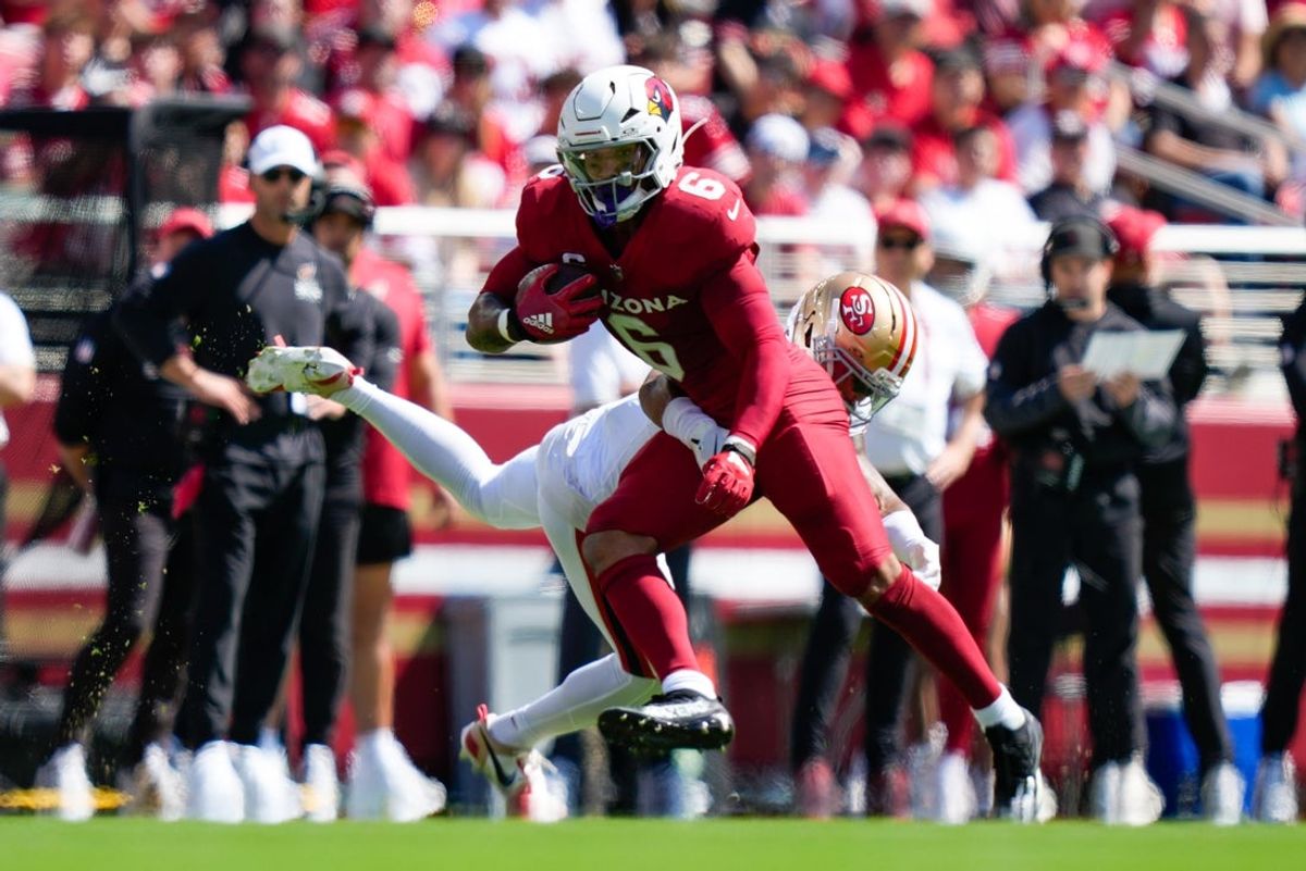 Sep 21, 2025; Santa Clara, California, USA; Arizona Cardinals running back James Conner (6) avoids the tackle by. San Francisco 49ers cornerback Deommodore Lenoir (2) during the first half at Levi's Stadium. Mandatory Credit: Kyle Terada-Imagn Images