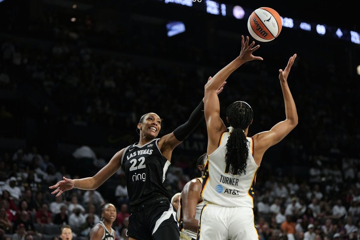 Sep 21, 2025; Las Vegas, Nevada, USA; Las Vegas Aces center A'ja Wilson (22) reaches for the ball against Indiana Fever forward Brianna Turner (11) during the fourth quarter in game one of the second round for the 2025 WNBA Playoffs at Michelob Ultra Arena. Mandatory Credit: Lucas Peltier-Imagn Images