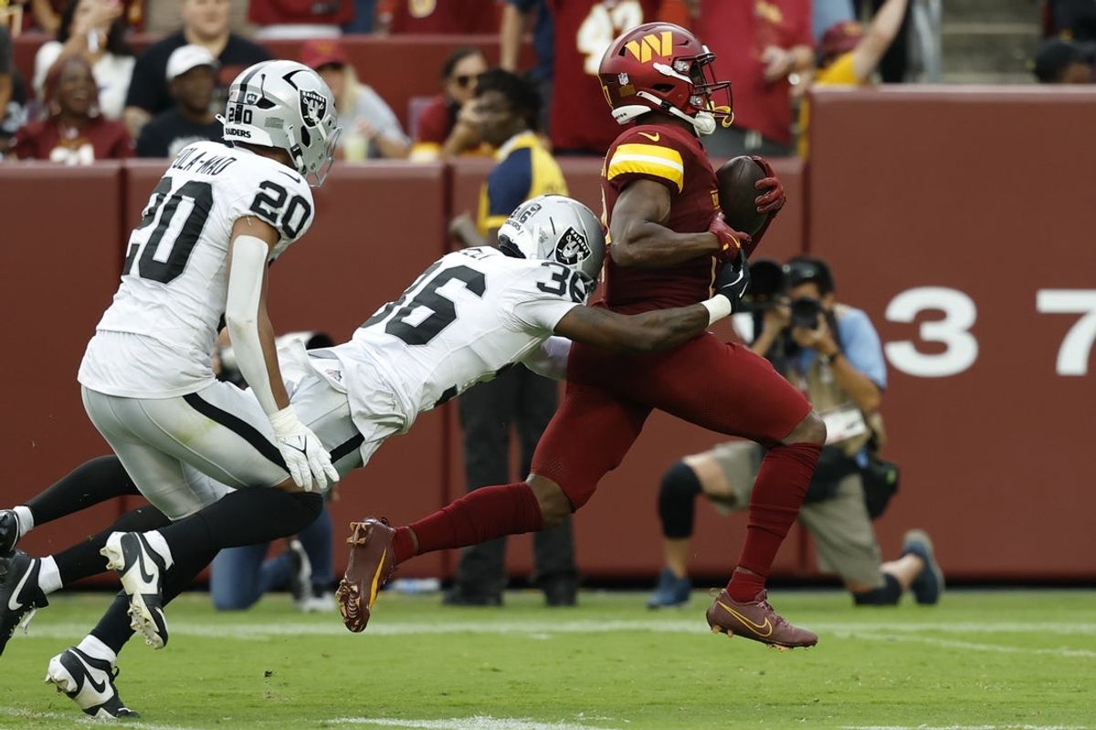Sep 21, 2025; Landover, Maryland, USA; Washington Commanders wide receiver Terry McLaurin (17) runs with the ball after making a catch as Las Vegas Raiders cornerback Kyu Blu Kelly (36) dives to attempt a tackle during the third quarter at Northwest Stadium. Mandatory Credit: Geoff Burke-Imagn Images