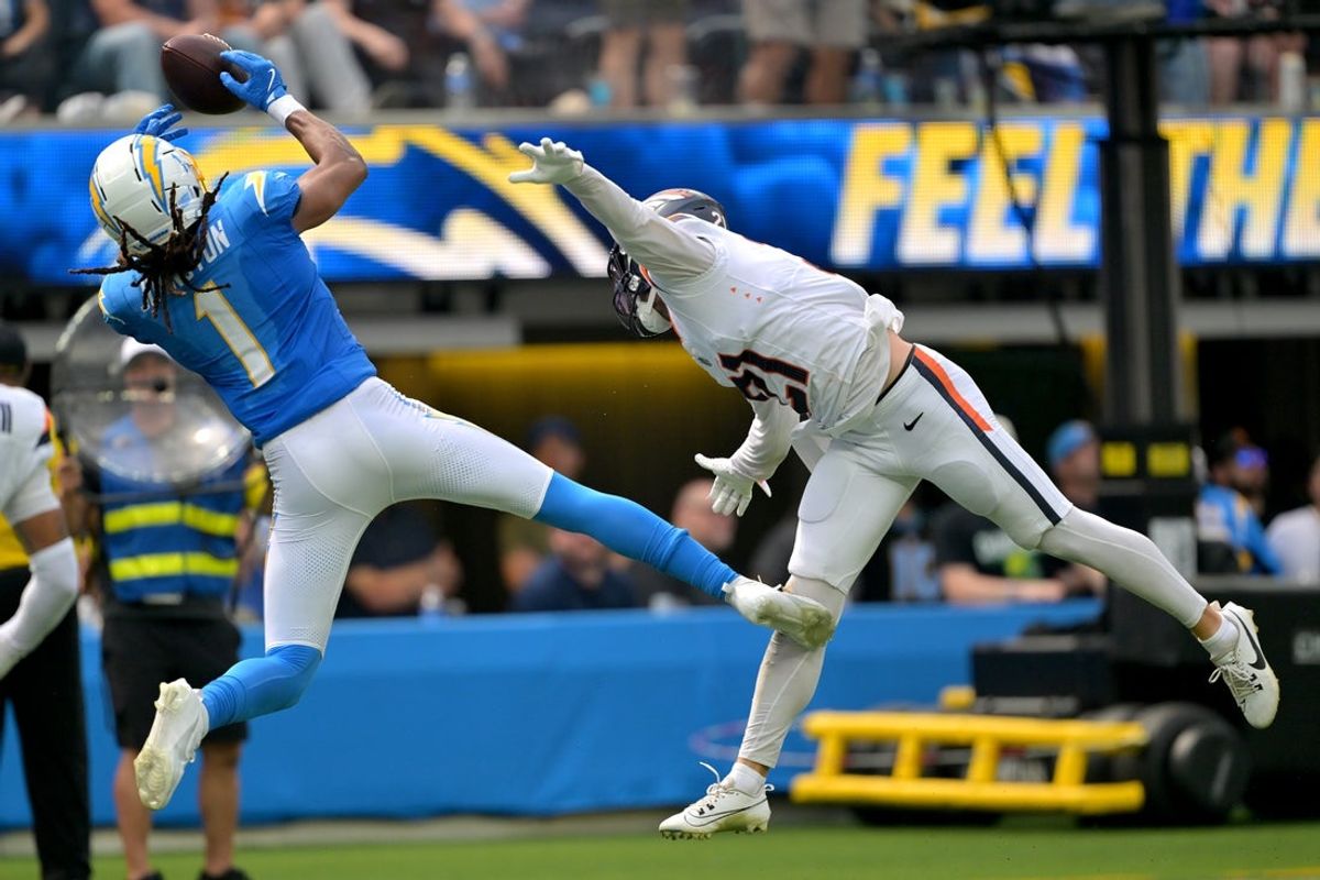 Sep 21, 2025; Inglewood, California, USA;  Los Angeles Chargers wide receiver Quentin Johnston (1) hangs on to a pass at the 3-yard line as he is defended by Denver Broncos cornerback Riley Moss (21) in the first half at SoFi Stadium. Mandatory Credit: Jayne Kamin-Oncea-Imagn Images