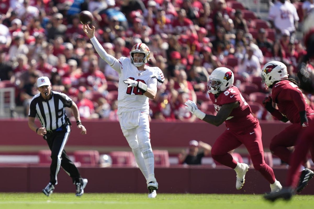 Sep 21, 2025; Santa Clara, California, USA; San Francisco 49ers quarterback Mac Jones (10) throws downfield as Arizona Cardinals linebacker Jordan Burch (52) defends during the second half at Levi's Stadium. Mandatory Credit: Kyle Terada-Imagn Images