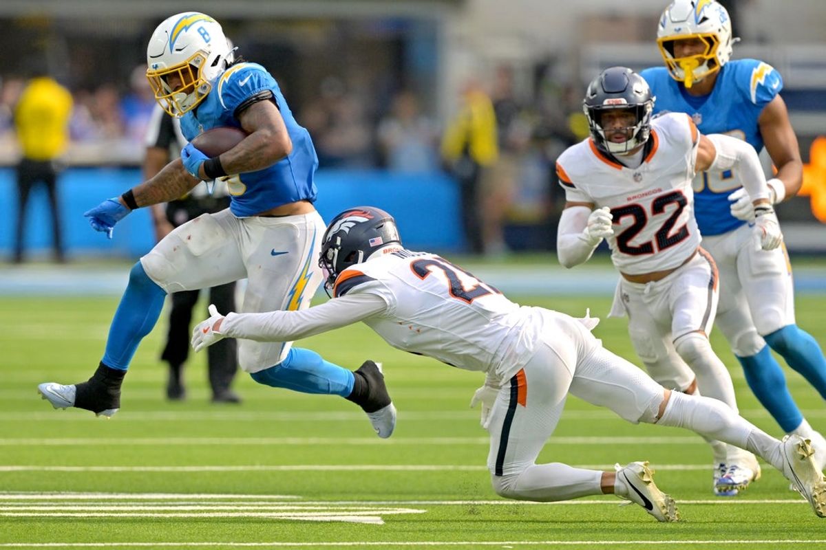 Sep 21, 2025; Inglewood, California, USA;  Los Angeles Chargers running back Omarion Hampton (8) is tripped up by Denver Broncos cornerback Riley Moss (21) after a first down in the fourth quarter at SoFi Stadium. Mandatory Credit: Jayne Kamin-Oncea-Imagn Images