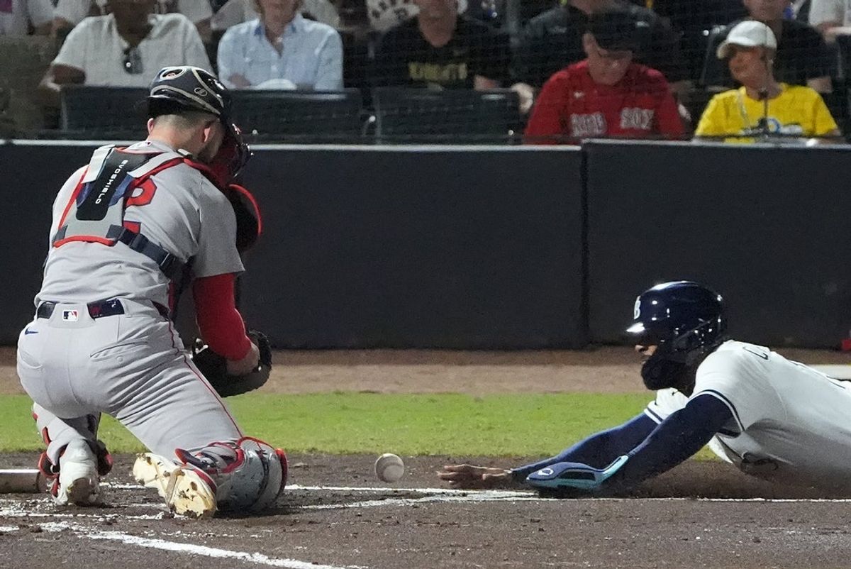 Sep 21, 2025; Tampa, Florida, USA; Tampa Bay Rays third base Junior Caminero (13) dives into home base safely as Boston Red Sox catcher Connor Wong (12) tries to make the tag during the first inning at George M. Steinbrenner Field. Mandatory Credit: Dave Nelson-Imagn Images