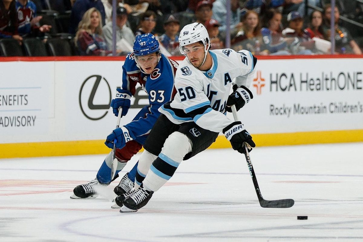 Sep 21, 2025; Denver, Colorado, USA; Utah Mammoth defenseman Sean Durzi (50) controls the puck under pressure from Colorado Avalanche center Zakhar Bardakov (93) in the second period at Ball Arena. Mandatory Credit: Isaiah J. Downing-Imagn Images