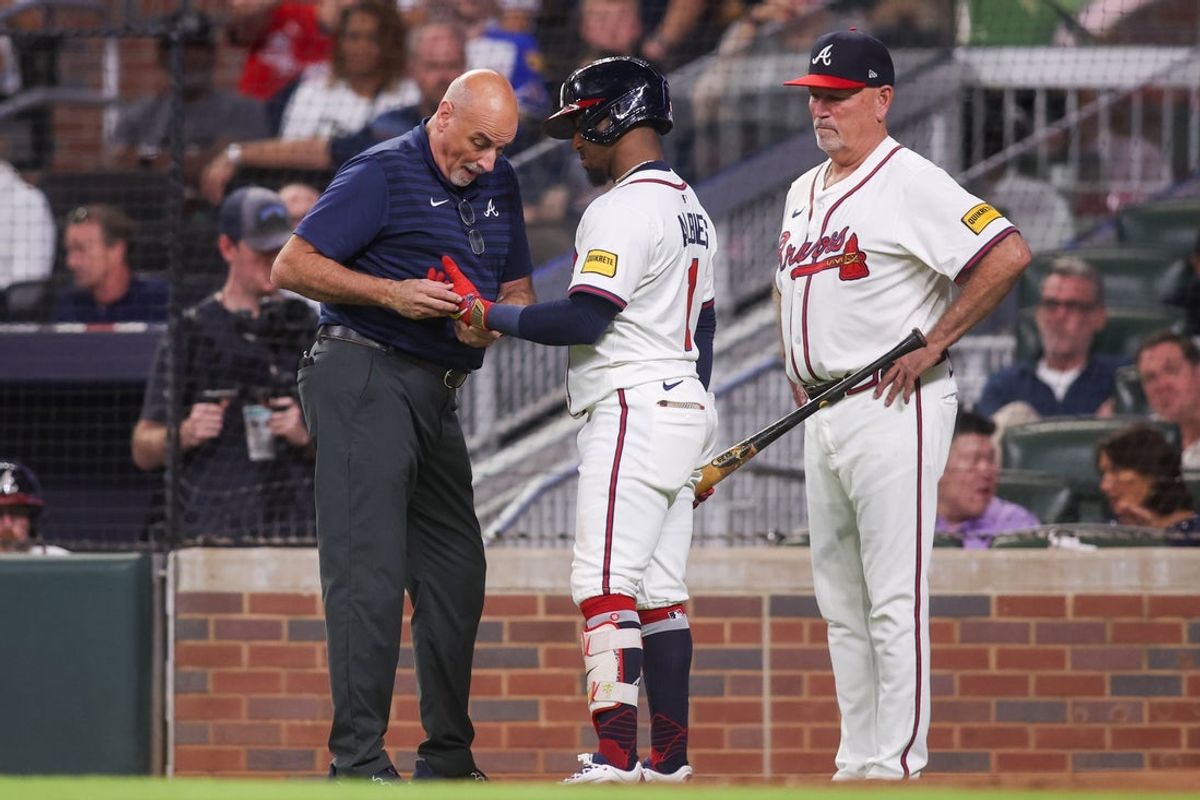 Sep 22, 2025; Atlanta, Georgia, USA; Atlanta Braves trainer George Poulis works on second baseman Ozzie Albies (1) against the Washington Nationals in the third inning at Truist Park. Mandatory Credit: Brett Davis-Imagn Images