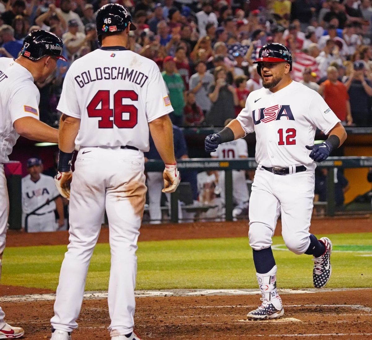 USA designated hitter Kyle Schwarber (12) celebrates with Mike Trout (L) and Paul Goldschmidt (46) after hitting a three-run home run against Great Britain during the World Baseball Classic at Chase Field in Phoenix on March 11, 2023.