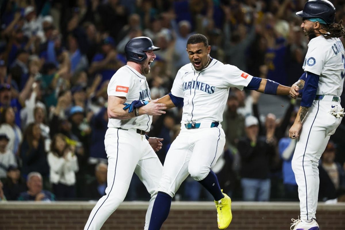 Sep 23, 2025; Seattle, Washington, USA; Seattle Mariners center fielder Julio Rodriguez (44) celebrates with pinch hitter Luke Raley (20, left) and shortstop J.P. Crawford (3) after scoring a run against the Colorado Rockies during the eighth inning at T-Mobile Park. Mandatory Credit: Joe Nicholson-Imagn Images