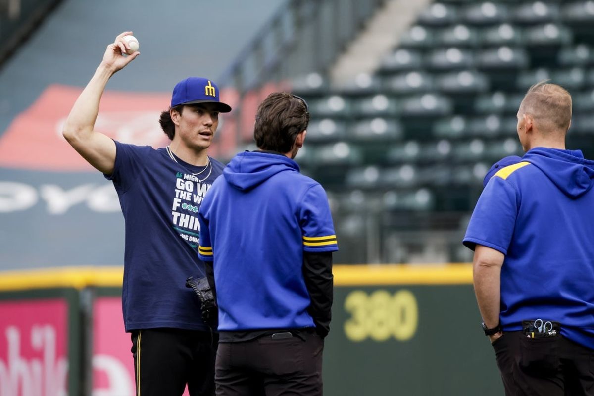 Sep 25, 2025; Seattle, Washington, USA; Seattle Mariners starting pitcher Bryan Woo (22) talks with team staff members after throwing in the outfield before a game against the Colorado Rockies at T-Mobile Park. Mandatory Credit: Joe Nicholson-Imagn Images