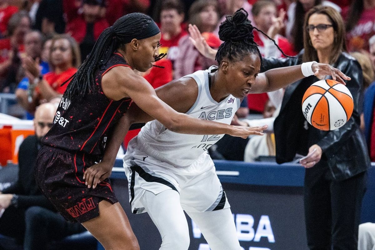 Sep 26, 2025; Indianapolis, Indiana, USA; Las Vegas Aces guard Chelsea Gray (12) dribbles the ball while Indiana Fever forward Natasha Howard (6) defends during game three of the second round for the 2025 WNBA Playoffs at Gainbridge Fieldhouse. Mandatory Credit: Trevor Ruszkowski-Imagn Images
