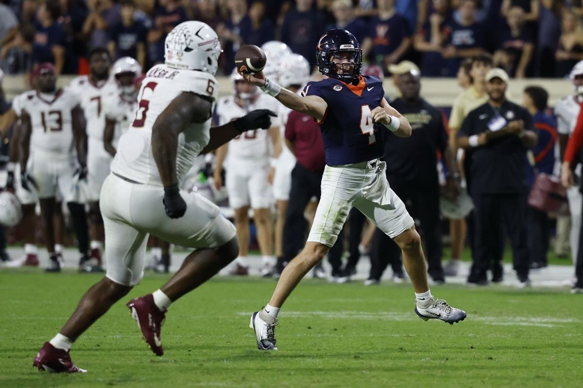 Sep 26, 2025; Charlottesville, Virginia, USA; Virginia Cavaliers quarterback Chandler Morris (4) passes the ball as Florida State Seminoles defensive lineman Darrell Jackson Jr. (6) chases in the first overtime period at Scott Stadium. Mandatory Credit: Geoff Burke-Imagn Images
