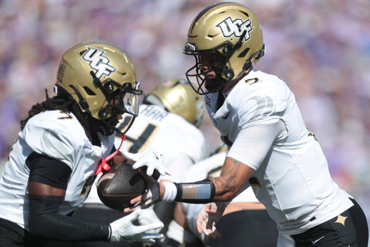 UCF Knights quarterback Tayven Jackson (2) hands the ball off to UCF Knights wide receiver Duane Thomas Jr. (7) during the first half of the game against Kansas State Wildcats at Bill Snyder Family Stadium on Sept. 27, 2025.