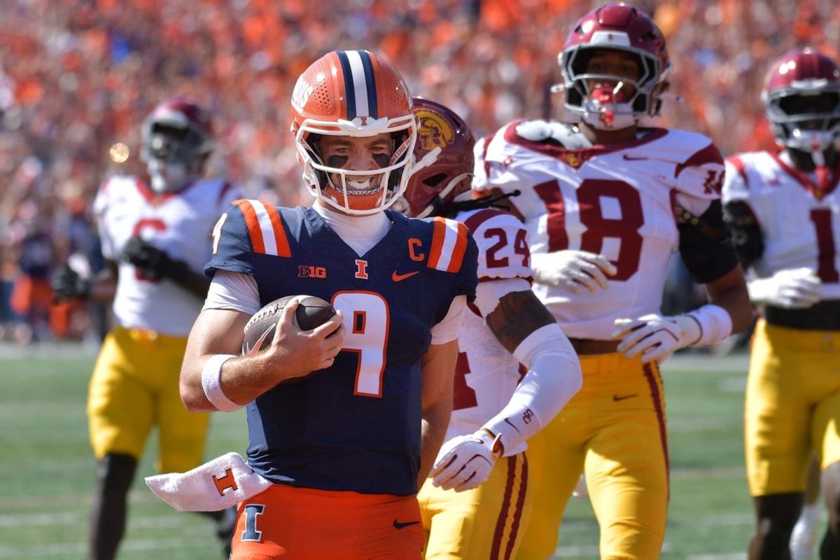 Sep 27, 2025; Champaign, Illinois, USA;  Illinois Fighting Illini quarterback Luke Altmyer (9) scores a touchdown during the first half against the Southern California Trojans at Memorial Stadium. Mandatory Credit: Ron Johnson-Imagn Images