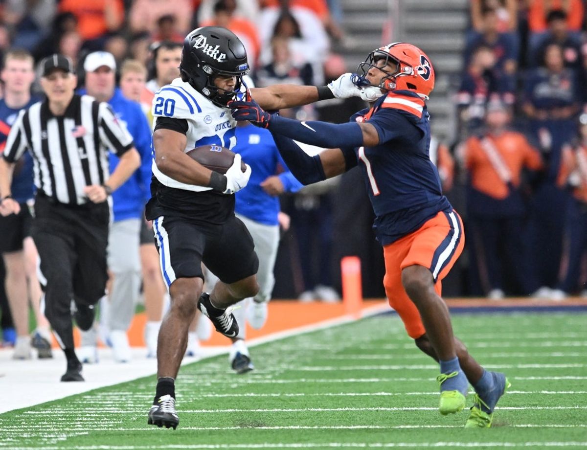 Sep 27, 2025; Syracuse, New York, USA; Duke Blue Devils running back Nate Sheppard (20) tries to hold off a tackle by Syracuse Orange defensive back Demetres Samuel Jr. (1) in the second quarter at the JMA Wireless Dome. Mandatory Credit: Mark Konezny-Imagn Images