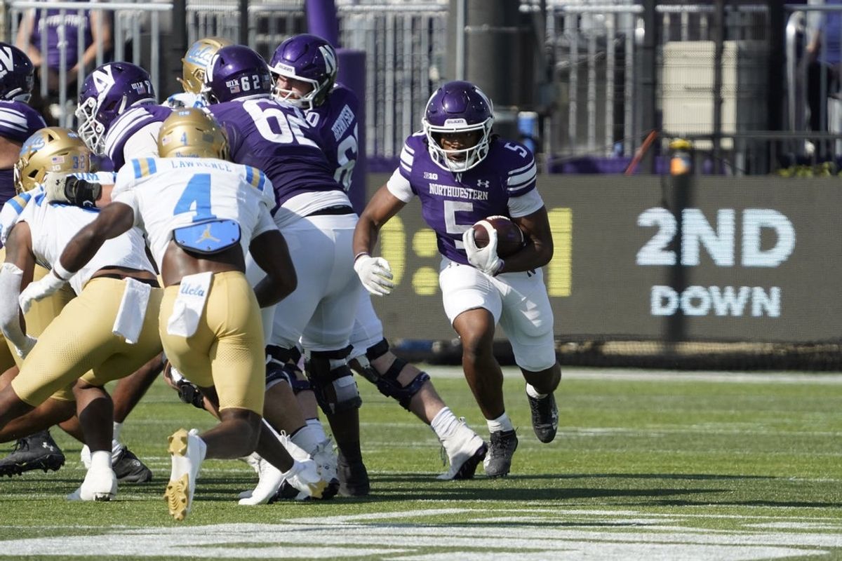 Sep 27, 2025; Evanston, Illinois, USA; Northwestern Wildcats running back Caleb Komolafe (5) runs the ball against the UCLA Bruins during the first half at Northwestern Medicine Field at Martin Stadium. Mandatory Credit: David Banks-Imagn Images