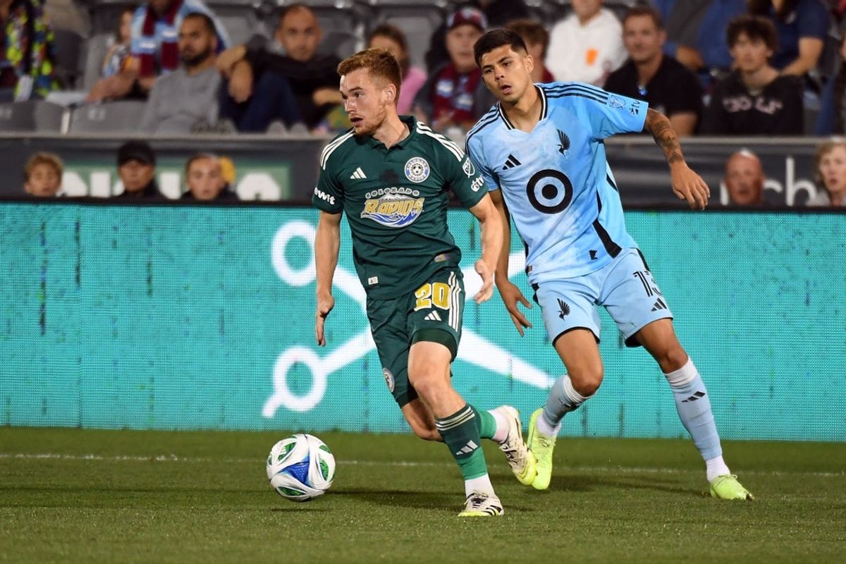 Sep 27, 2025; Commerce City, Colorado, USA; Colorado Rapids midfielder Connor Ronan (20) moves the ball against Minnesota United defender Anthony Markanich (13) during the first half at Dick's Sporting Goods Park. Mandatory Credit: Christopher Hanewinckel-Imagn Images