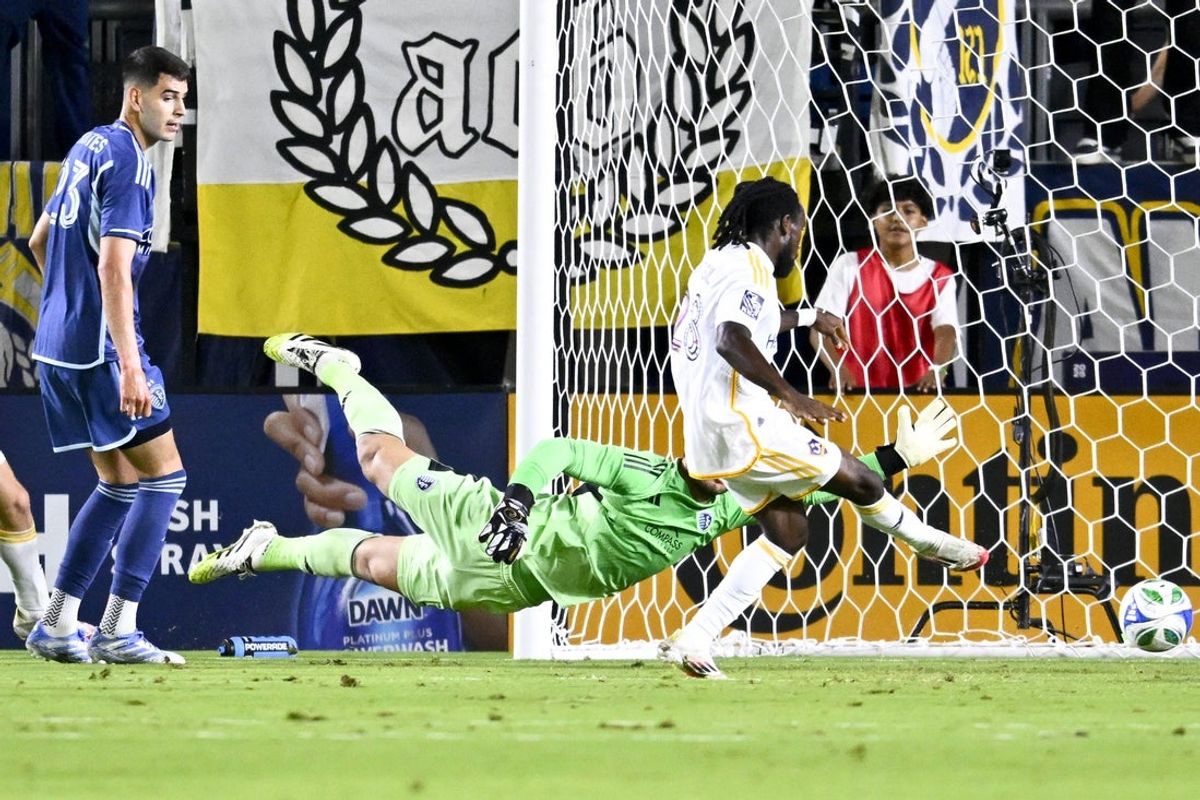 Sep 27, 2025; Carson, California, USA; LA Galaxy forward Joseph Paintsil (28) scores a goal against Sporting Kansas City goalkeeper John Pulskamp (1) during the first half at Dignity Health Sports Park. Mandatory Credit: Kelvin Kuo-Imagn Images