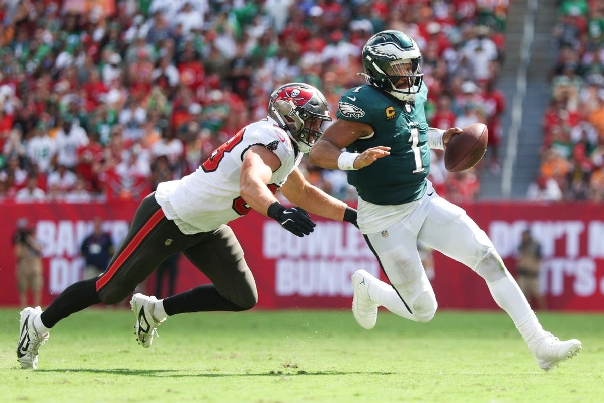 Sep 28, 2025; Tampa, Florida, USA; Philadelphia Eagles quarterback Jalen Hurts (1) attempts to evade Tampa Bay Buccaneers linebacker Anthony Nelson (98) during the third quarter at Raymond James Stadium. Mandatory Credit: Nathan Ray Seebeck-Imagn Images