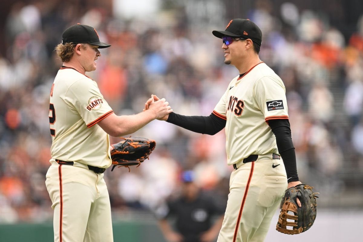 Sep 28, 2025; San Francisco, California, USA;  San Francisco Giants first baseman Wilmer Flores, right, shakes hands with San Francisco Giants starting pitcher Logan Webb (62) after being taken out of the game against the Colorado Rockies in the third inning at Oracle Park. Mandatory Credit: Eakin Howard-Imagn Images