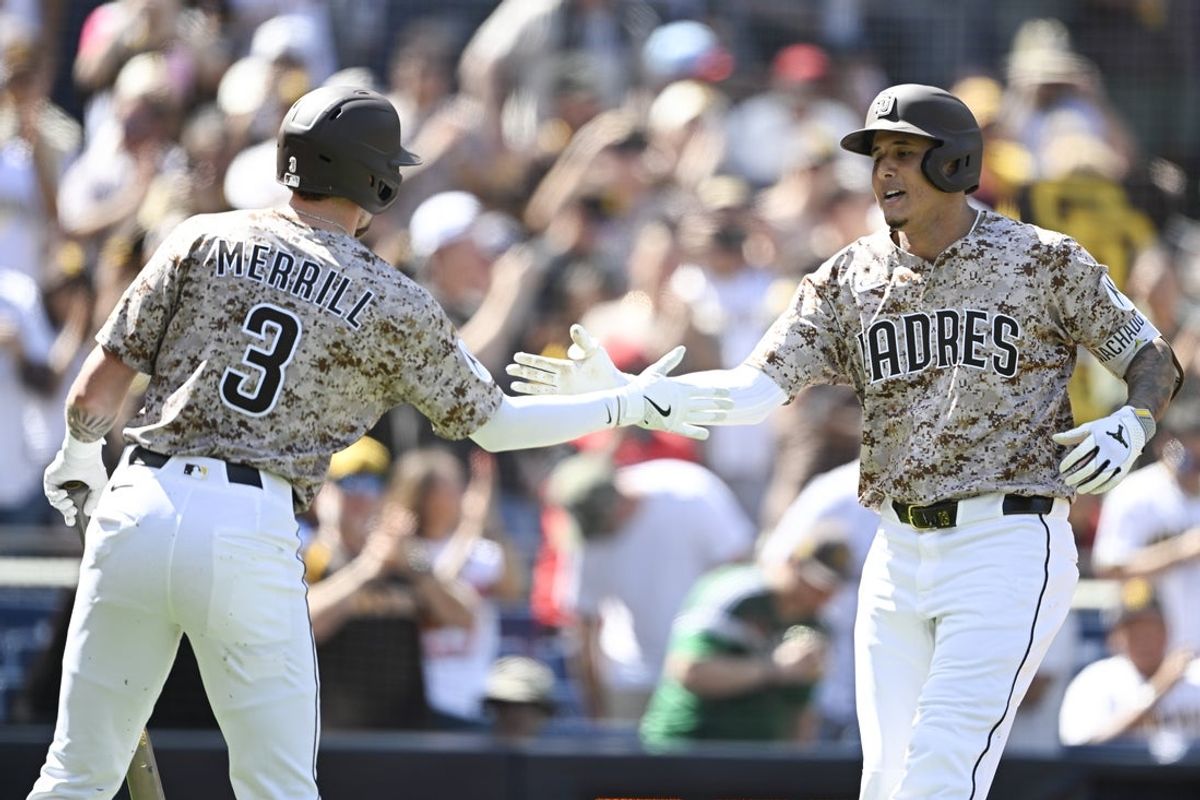 Sep 28, 2025; San Diego, California, USA; San Diego Padres third baseman Manny Machado (13) is congratulated by Jackson Merrill (3) after hitting a solo home run during the third inning against the Arizona Diamondbacks at Petco Park. Mandatory Credit: Denis Poroy-Imagn Images
