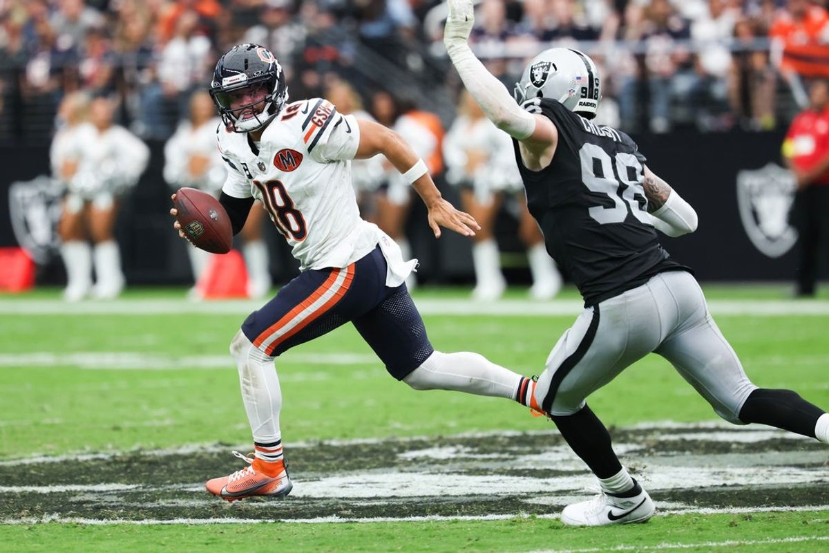 Sep 28, 2025; Paradise, Nevada, USA; Chicago Bears quarterback Caleb Williams (18) looks for an open receiver while being pressured by Las Vegas Raiders defensive end Maxx Crosby (98) in the second quarter at Allegiant Stadium. Mandatory Credit: Kiyoshi Mio-Imagn Images