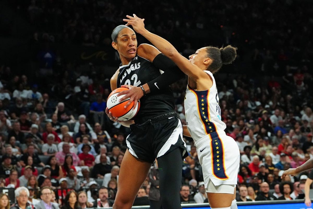 Sep 30, 2025; Las Vegas, Nevada, USA; Las Vegas Aces center A'ja Wilson (22) pulls a rebound away from Indiana Fever guard Aerial Powers (23) during the second quarter of  game five of the second round for the 2025 WNBA Playoffs at Michelob Ultra Arena. Mandatory Credit: Stephen R. Sylvanie-Imagn Images