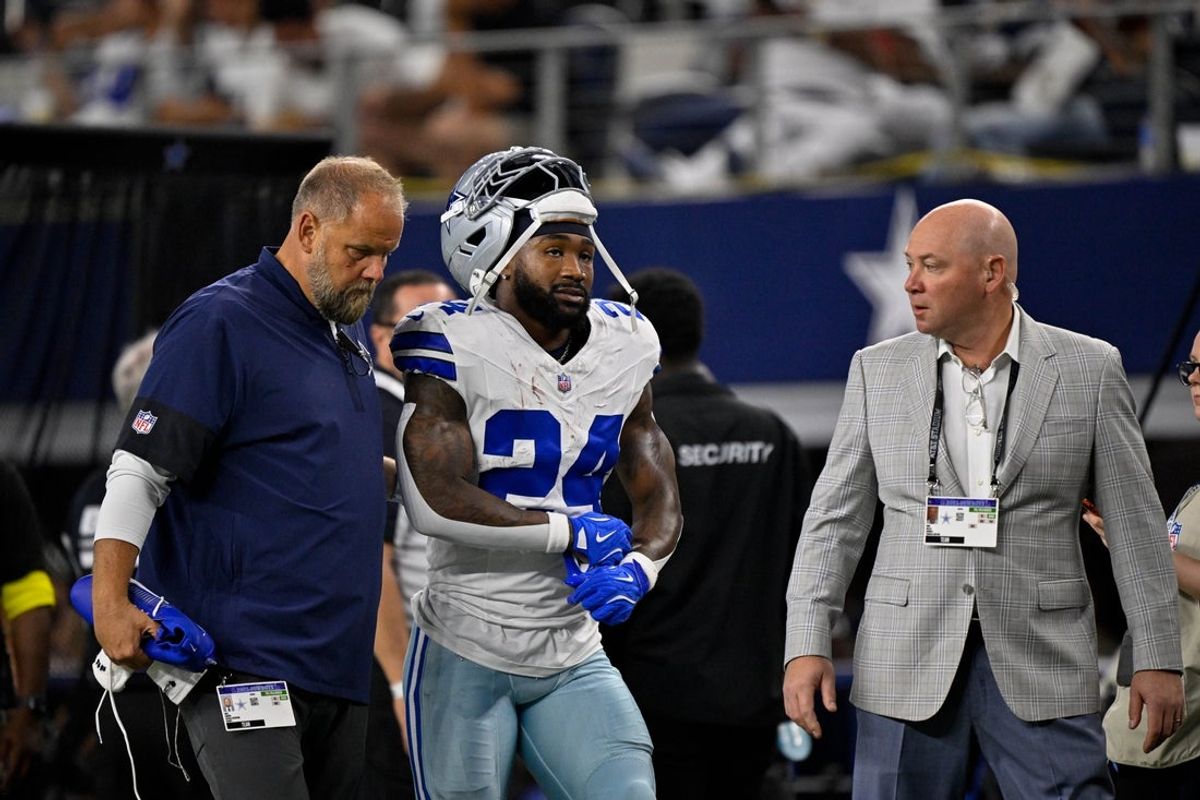 Sep 28, 2025; Arlington, Texas, USA; Dallas Cowboys running back Miles Sanders (24) walks off the field with team staff during the game between the Dallas Cowboys and the Green Bay Packers at AT&T Stadium. Mandatory Credit: Jerome Miron-Imagn Images