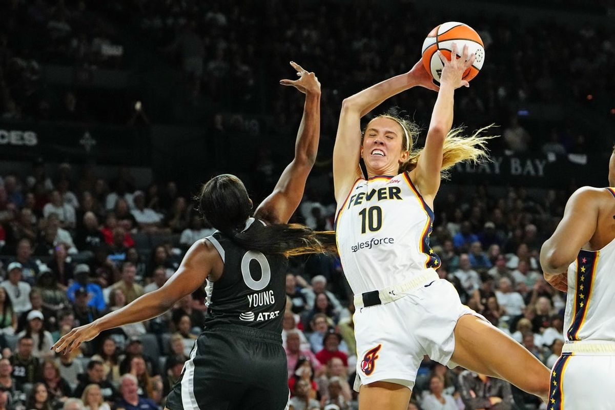 Sep 30, 2025; Las Vegas, Nevada, USA; Indiana Fever guard Lexie Hull (10) pulls a rebound away from Las Vegas Aces guard Jackie Young (0) during the third quarter of game five of the second round for the 2025 WNBA Playoffs at Michelob Ultra Arena. Mandatory Credit: Stephen R. Sylvanie-Imagn Images