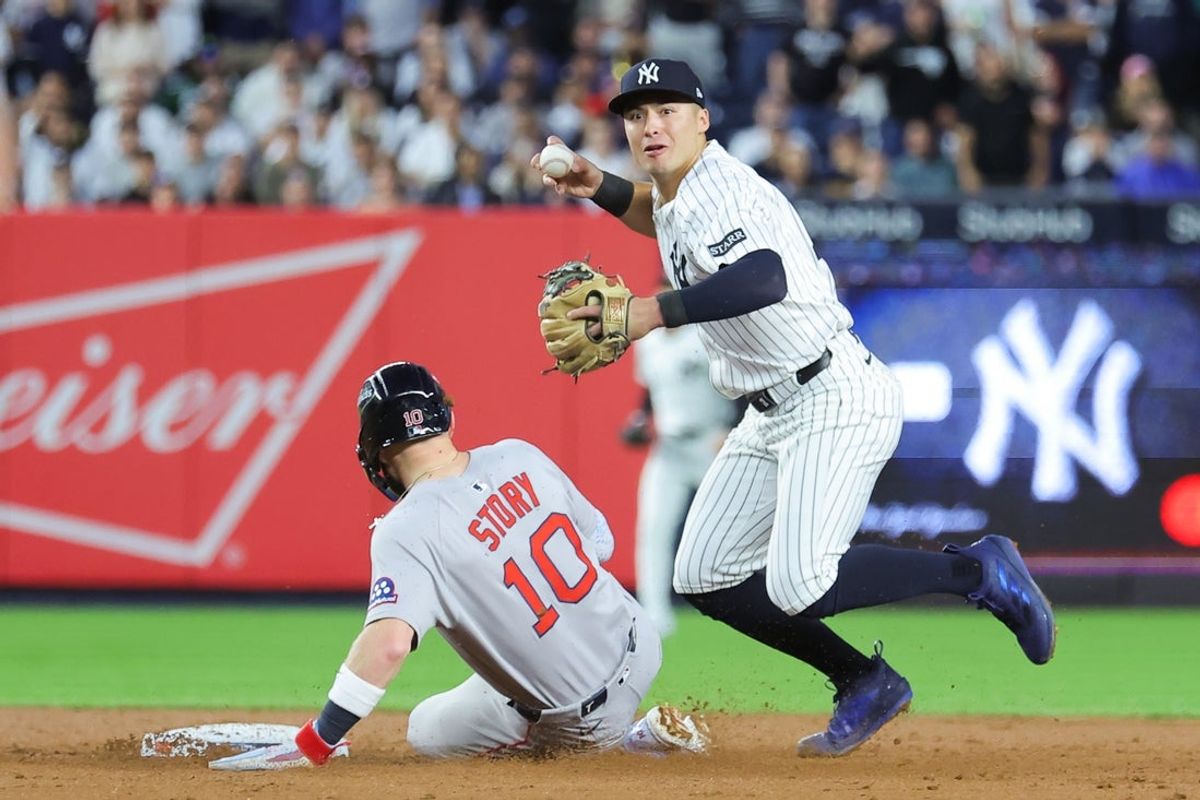 Oct 1, 2025; Bronx, New York, USA; New York Yankees shortstop Anthony Volpe (11) turns a double play on Boston Red Sox shortstop Trevor Story (10) and Boston Red Sox third baseman Alex Bregman (2) (not pictured) during the third inning of game two of the Wildcard round for the 2025 MLB playoffs at Yankee Stadium. Mandatory Credit: Brad Penner-Imagn Images