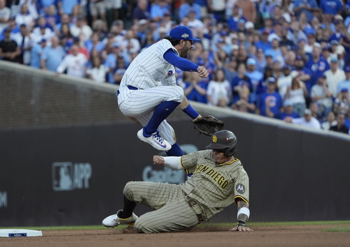 Oct 2, 2025; Chicago, Illinois, USA; Chicago Cubs shortstop Dansby Swanson (7) tags out San Diego Padres third baseman Manny Machado (13) during the sixth inning during game three of the Wildcard round for the 2025 MLB playoffs at Wrigley Field. Mandatory Credit: David Banks-Imagn Images