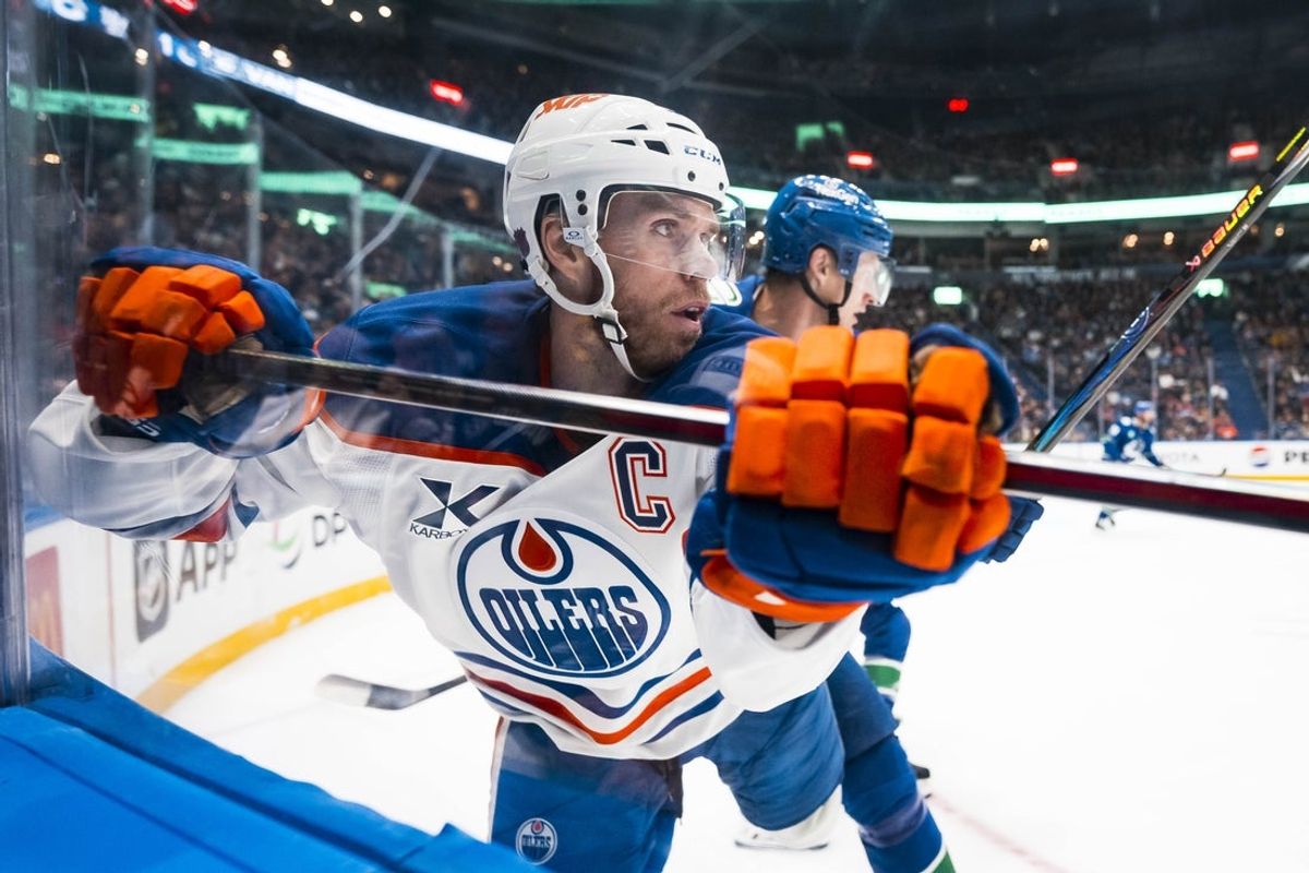 Oct 3, 2025; Vancouver, British Columbia, CAN; Vancouver Canucks defenseman Tyler Myers (57) checks Edmonton Oilers forward Connor McDavid (97) in the second period at Rogers Arena. Mandatory Credit: Bob Frid-Imagn Images