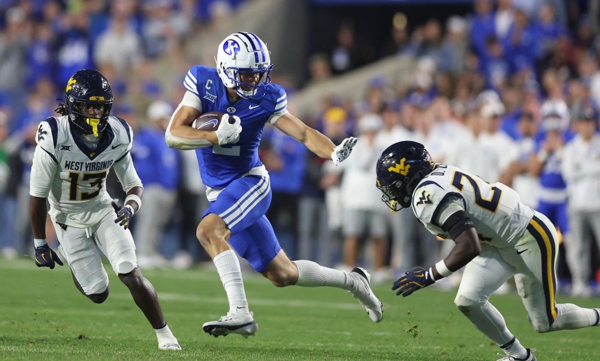 Oct 3, 2025; Provo, Utah, USA; Brigham Young Cougars wide receiver Chase Roberts (2) runs after a catch against West Virginia Mountaineers safety Derek Carter Jr. (13) and safety Darrian Lewis (24) during the fourth quarter at LaVell Edwards Stadium. Mandatory Credit: Rob Gray-Imagn Images