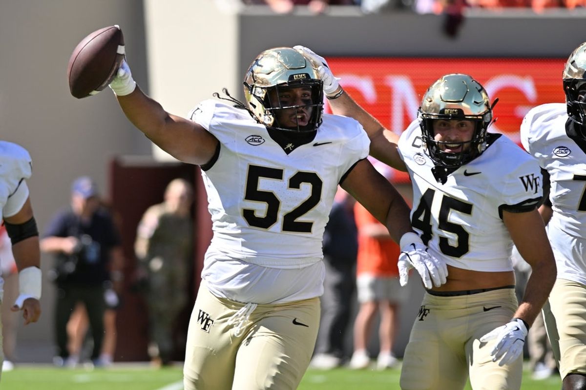 Oct 4, 2025; Blacksburg, Virginia, USA;  Wake Forest Demon Deacons defensive lineman Dallas Afalava (52) and defensive back Nick Andersen (45) celebrate a fumble recovery during the first quarter against the Virginia Tech Hokies at Lane Stadium. Mandatory Credit: Brian Bishop-Imagn Images