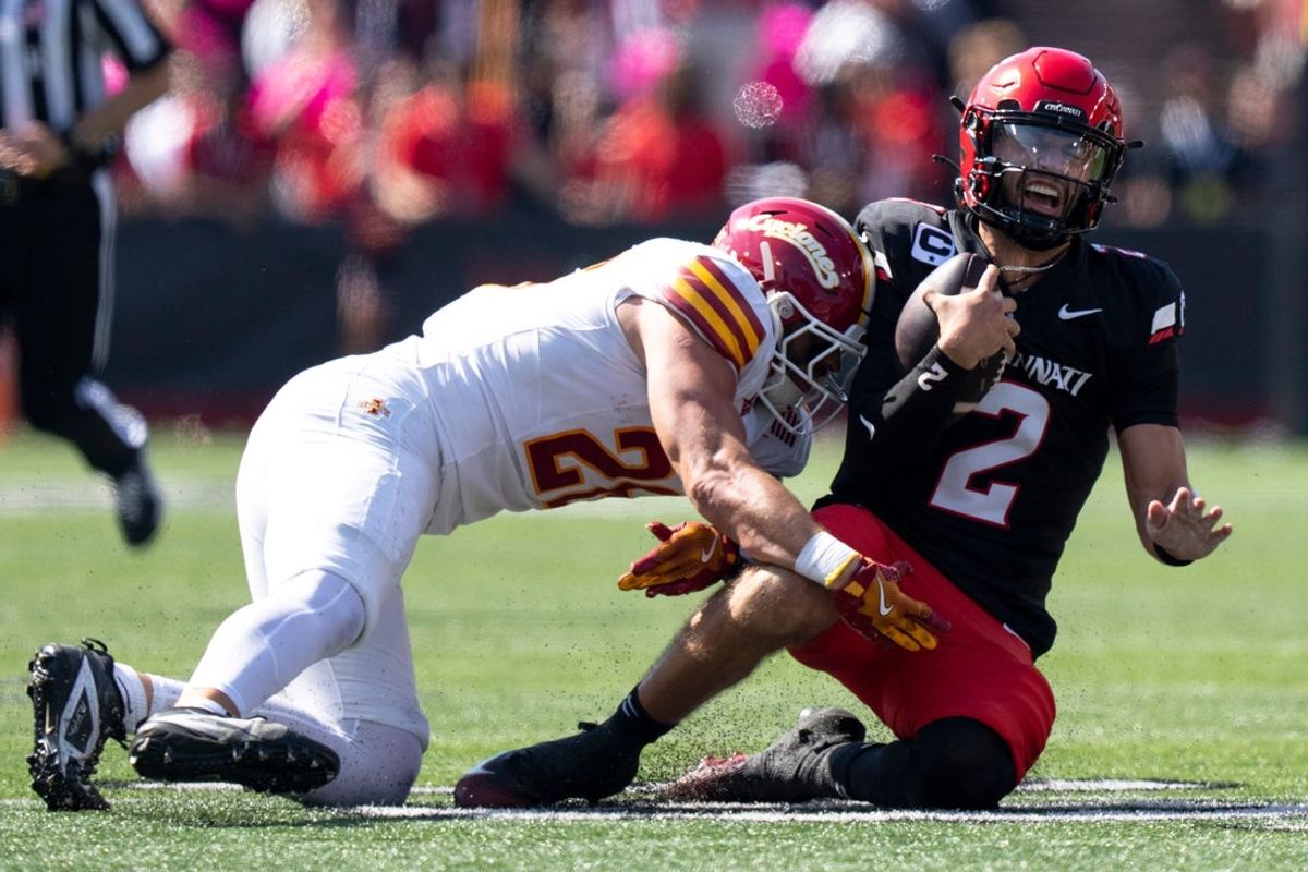 Iowa State Cyclones defensive back Khijohnn Cummings-Coleman (20) tackles Cincinnati Bearcats quarterback Brendan Sorsby (2) in the first quarter of the NCAA football game between the Cincinnati Bearcats and Iowa State Cyclones at Nippert Stadium in Cincinnati on Oct. 4, 2025.