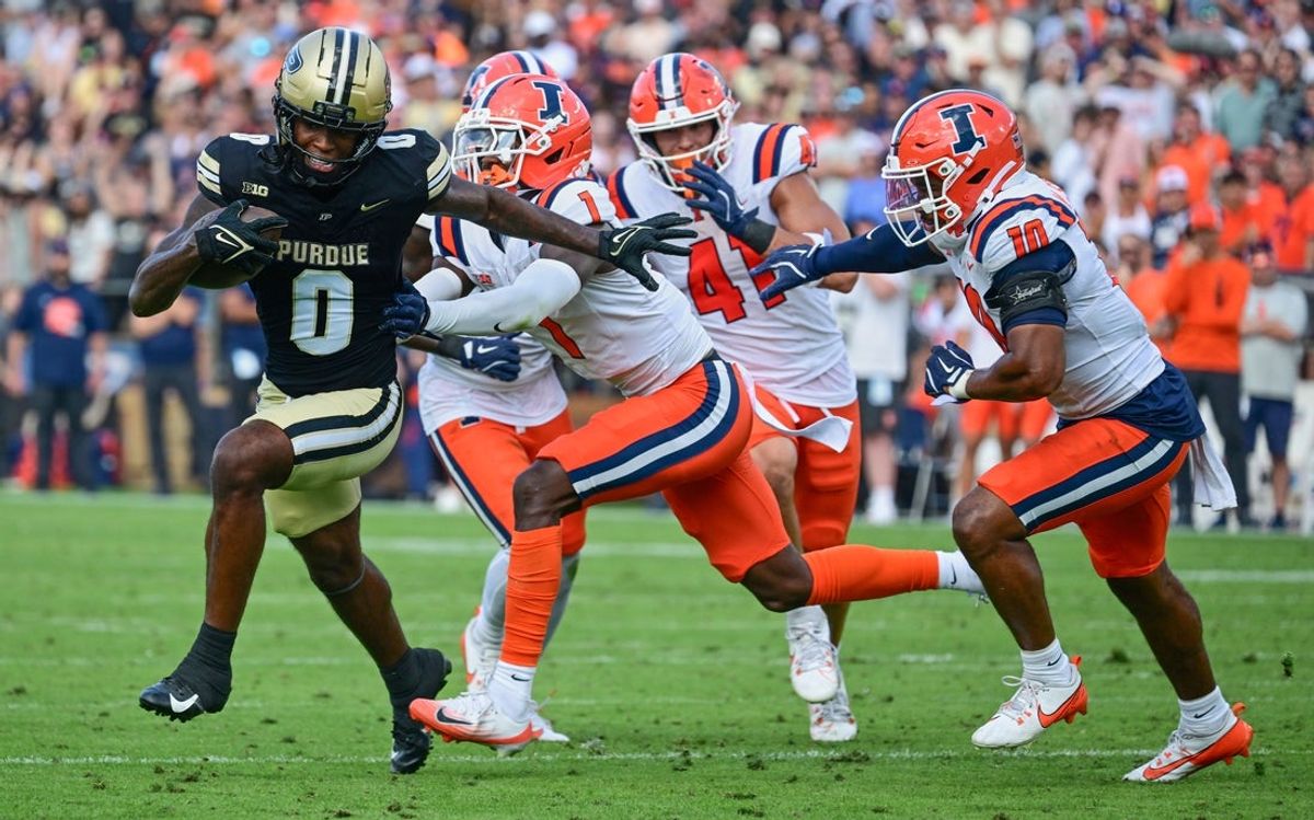 Oct 4, 2025; West Lafayette, Indiana, USA; Purdue Boilermakers wide receiver Nitro Tuggle runs with the ball against Illinois Fighting Illini defensive back Kaleb Patterson (1), linebacker James Kreutz (41) and defensive back Miles Scott (10) during the second half at Ross-Ade Stadium. Mandatory Credit: Marc Lebryk-Imagn Images