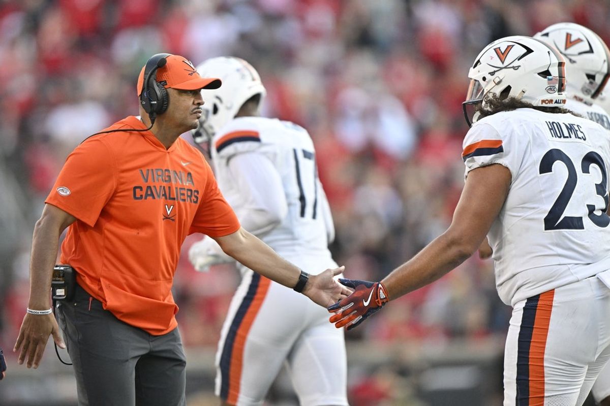 Oct 4, 2025; Louisville, Kentucky, USA; Virginia Cavaliers head coach Tony Elliott celebrates with defensive lineman Jacob Holmes (23) during the second half against the Louisville Cardinals at L&N Federal Credit Union Stadium. Virginia defeated Louisville 30-27. Mandatory Credit: Jamie Rhodes-Imagn Images