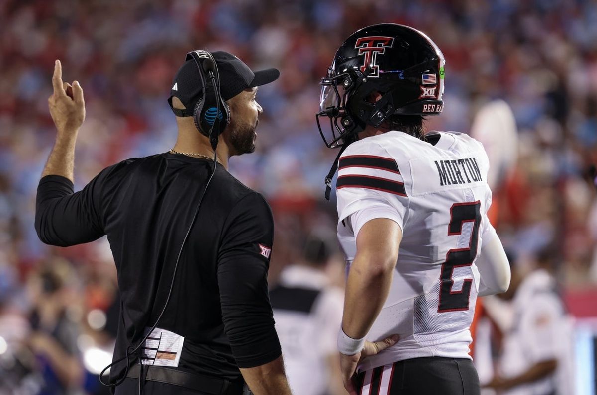 Oct 4, 2025; Houston, Texas, USA; Texas Tech Raiders wide receiver coach Dustin Johnson talks with quarterback Behren Morton (2) on the sidelines between possession against the Houston Cougars in the first half at TDECU Stadium. Mandatory Credit: Thomas Shea-Imagn Images