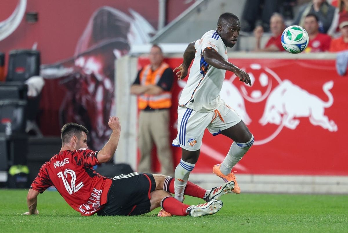 Oct 4, 2025; Harrison, New Jersey, USA; New York Red Bulls defender Dylan Nealis (12) plays the ball away from FC Cincinnati forward Kevin Denkey (9) during the second half at Sports Illustrated Stadium. Mandatory Credit: Vincent Carchietta-Imagn Images