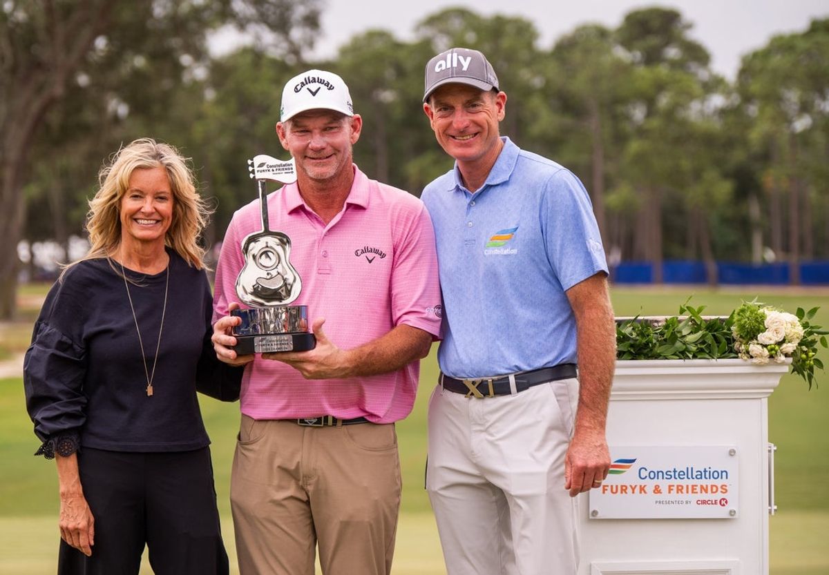 Tommy Gainey holds the Constellation Furyk & Friends trophy after winning the Constellation Furyk & Friends PGA Tour Champions event held at Timuquana Country Club in Jacksonville, Fl., Sunday October 5, 2025 while flanked by Tabitha Furyk, left and her husband golf great Jim Gary. Tommy Gainey won the tournament by shooting -14. Cameron Percy placed second with -12. [Doug Engle/Florida Times-Union]