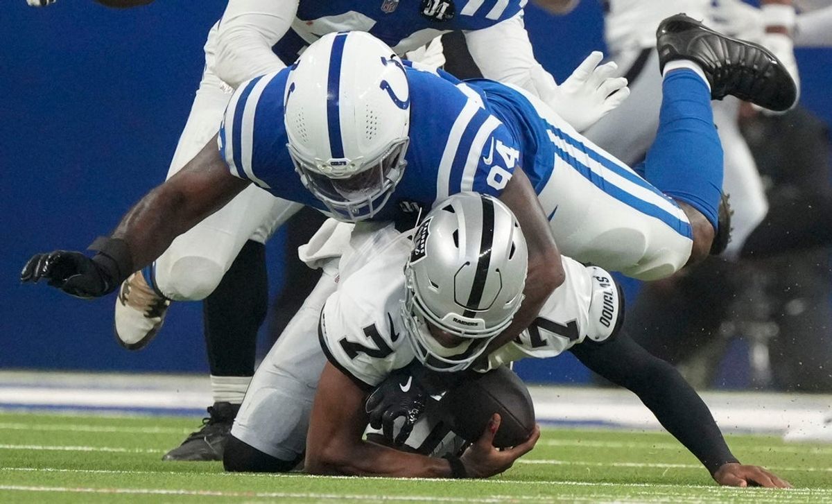 Indianapolis Colts defensive end Tyquan Lewis (94) brings down Las Vegas Raiders quarterback Geno Smith (7) on Sunday, Oct. 5, 2025, during a game at Lucas Oil Stadium in Indianapolis. The Colts defeated the Raiders 40-6.