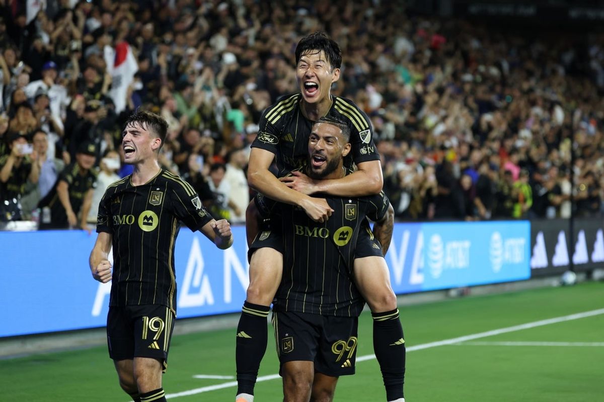 Oct 5, 2025; Los Angeles, California, USA;  LAFC forward Denis Bouanga (99) celebrates with midfielder Andrew Moran (19) and forward Son Heung-Min (top) after scoring a goal during the second half against Atlanta United FC at BMO Stadium. Mandatory Credit: Kiyoshi Mio-Imagn Images